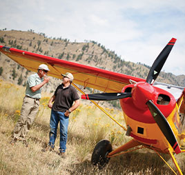 Photo of two people standing in front of plane. Link to Gifts of Cash, Checks, and Credit Cards.